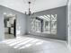 Bright living room with modern chandelier, white tiled floors, and a view to backyard pergola at 3417 Pershing Ave, Orlando, FL 32812