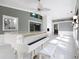 Bright living room showcases tile floors, white piano, fireplace, and seamless flow to kitchen and dining areas at 3417 Pershing Ave, Orlando, FL 32812