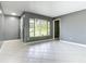 Living room features neutral walls, white tile floors, large window with a view to the front yard at 3417 Pershing Ave, Orlando, FL 32812