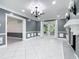 Bright living room with fireplace, sconces, chandelier, and tile floors at 3417 Pershing Ave, Orlando, FL 32812
