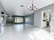 Open living room features white tile floors, gray walls, and a decorative chandelier at 3417 Pershing Ave, Orlando, FL 32812