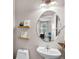 Powder room features floating shelves, an oval mirror, and pedestal sink at 3472 Gretchen Dr, Ocoee, FL 34761