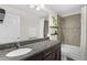 Bathroom with a large mirror, granite countertop, and tiled shower and tub at 3472 Gretchen Dr, Ocoee, FL 34761
