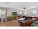 Bonus room featuring wood flooring, sofa, TV, ceiling fan and natural light from the windows at 3472 Gretchen Dr, Ocoee, FL 34761