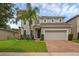 Charming two-story home featuring a well-manicured lawn and a brick-paved driveway leading to a two-car garage at 3472 Gretchen Dr, Ocoee, FL 34761