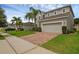 Charming two-story house featuring a lush lawn, two-car garage, and beautiful landscaping with mature palm trees at 3472 Gretchen Dr, Ocoee, FL 34761