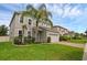Charming two-story house featuring a lush lawn, two-car garage, and beautiful landscaping with mature palm trees at 3472 Gretchen Dr, Ocoee, FL 34761