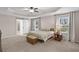 Serene main bedroom with tray ceiling, carpet, barn door and natural light from the windows at 3472 Gretchen Dr, Ocoee, FL 34761