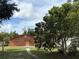 Side view of a single-story home with a large tree in the front yard, showing the side entrance at 3700 Washington St, Sanford, FL 32771