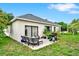 Backyard patio with a grill, seating, and a well-maintained lawn, perfect for outdoor activities at 501 Lake Cummings Way, Lake Alfred, FL 33850