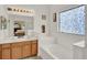 Large bathroom features a soaking tub, dual sink vanity, and unique stained-glass window at 501 Lake Cummings Way, Lake Alfred, FL 33850