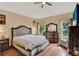 Relaxing bedroom with a cozy bed, hardwood floors, and natural light from the windows at 501 Lake Cummings Way, Lake Alfred, FL 33850
