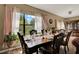Formal dining room with a large window offering backyard views and elegant furnishings at 501 Lake Cummings Way, Lake Alfred, FL 33850