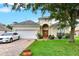 Charming single-Gathering home showcasing a well-manicured lawn, brick driveway, and white car at 501 Lake Cummings Way, Lake Alfred, FL 33850