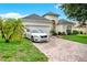 Charming single-Gathering home showcasing a well-manicured lawn, brick driveway, and white car at 501 Lake Cummings Way, Lake Alfred, FL 33850
