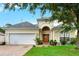 Charming single-Gathering home showcasing a well-manicured lawn, brick driveway, and attached two-car garage at 501 Lake Cummings Way, Lake Alfred, FL 33850