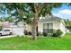 Charming single-Gathering home showcasing a well-manicured lawn, brick driveway, and attached two-car garage at 501 Lake Cummings Way, Lake Alfred, FL 33850