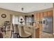 Bright kitchen featuring bar seating, stainless steel refrigerator, and a window with a view to the outside at 501 Lake Cummings Way, Lake Alfred, FL 33850