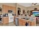 Bright open-concept kitchen featuring stainless steel appliances, granite countertops, and neutral-toned cabinetry at 501 Lake Cummings Way, Lake Alfred, FL 33850