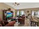 Open-concept living room boasts stylish furnishings, a ceiling fan, and large windows offering ample natural light at 501 Lake Cummings Way, Lake Alfred, FL 33850