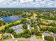 Panoramic aerial view of the community highlighting a scenic lake, golf course, tennis courts, and lush landscaping at 533 Quail Down Dr, Debary, FL 32713