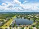 Wide aerial view of a beautiful lake surrounded by homes in the community at 533 Quail Down Dr, Debary, FL 32713