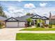 Charming home featuring a three-car garage, well-manicured lawn, and decorative landscaping at 533 Quail Down Dr, Debary, FL 32713