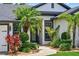 Charming home entrance with lush landscaping, palm trees, and a welcoming walkway at 533 Quail Down Dr, Debary, FL 32713