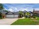 Home featuring manicured lawn, landscaping and a three-car garage at 533 Quail Down Dr, Debary, FL 32713