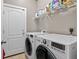 Bright laundry room with white washer and dryer units, as well as wire shelving at 533 Quail Down Dr, Debary, FL 32713