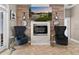 Living room with modern fireplace and wood paneling featuring comfortable black chairs at 533 Quail Down Dr, Debary, FL 32713