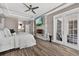 This main bedroom boasts a modern fireplace, TV, wood floors, ceiling fan, and lanai access at 533 Quail Down Dr, Debary, FL 32713