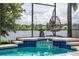 Relaxing screened-in pool area with a water view and a comfortable hanging lounge chair at 533 Quail Down Dr, Debary, FL 32713