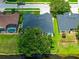 Aerial view of home's backyard featuring well-manicured lawn, screened enclosure, and lush trees near a tranquil pond at 533 Quail Down Dr, Debary, FL 32713