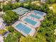 A vibrant aerial view of the six community tennis courts, surrounded by lush greenery and ample parking at 533 Quail Down Dr, Debary, FL 32713