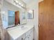 A bathroom with single sink vanity, mirrored cabinet and doorway to an adjacent bedroom at 5409 Holtland Dr, Apopka, FL 32712