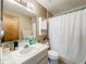 Bathroom features a shower with curtain, cabinet, standard sink, and toilet at 5409 Holtland Dr, Apopka, FL 32712