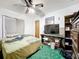 This bedroom includes a ceiling fan, and is furnished with a TV, bed, dresser, and shelving unit at 5409 Holtland Dr, Apopka, FL 32712