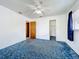 Bedroom with blue carpet, ceiling fan, one window with blue curtains, and a closet at 5409 Holtland Dr, Apopka, FL 32712