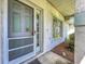 Close-up of the front door and window, featuring a screen door and exterior color accents at 5409 Holtland Dr, Apopka, FL 32712