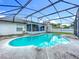 Screened pool with clear blue water and patio area next to enclosed porch at 5409 Holtland Dr, Apopka, FL 32712