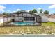 Pool view of a screened in pool and patio next to a patchy grass yard at 5409 Holtland Dr, Apopka, FL 32712