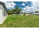 Spacious backyard with a green lawn, surrounded by trees and neighboring homes, perfect for outdoor activities at 5908 Sw 115 Street Rd, Ocala, FL 34476