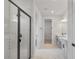 Bright bathroom with white marble floors and a glass-enclosed shower and double vanity sinks at 5908 Sw 115 Street Rd, Ocala, FL 34476
