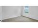 Bright bedroom featuring neutral carpet, white walls, and a large window at 5908 Sw 115 Street Rd, Ocala, FL 34476
