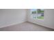 Cozy bedroom with a neutral carpet, large window with view, and white trim at 5908 Sw 115 Street Rd, Ocala, FL 34476