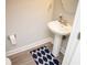 Neat powder room with white pedestal sink, decorative rug, and ample space at 5963 Glory Bower Dr, Winter Garden, FL 34787