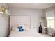 Cozy bedroom featuring a padded headboard, bright window, and a full-length mirror at 5963 Glory Bower Dr, Winter Garden, FL 34787