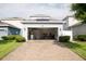 Exterior view of garage with solar panels and a brick-paved driveway at 5963 Glory Bower Dr, Winter Garden, FL 34787