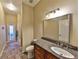 Well-lit bathroom with granite counters, single sink, and a shower with a glass door at 604 Timberwilde Ct, Winter Springs, FL 32708